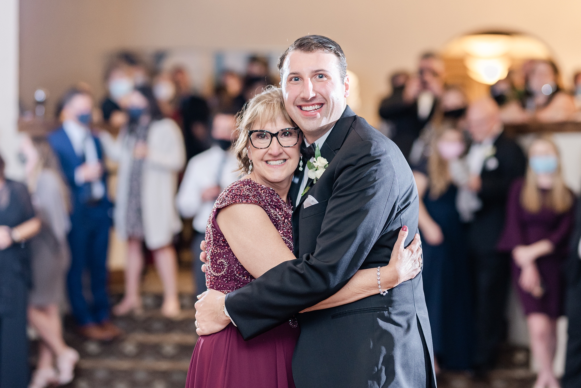 groom and mom pose during wedding reception