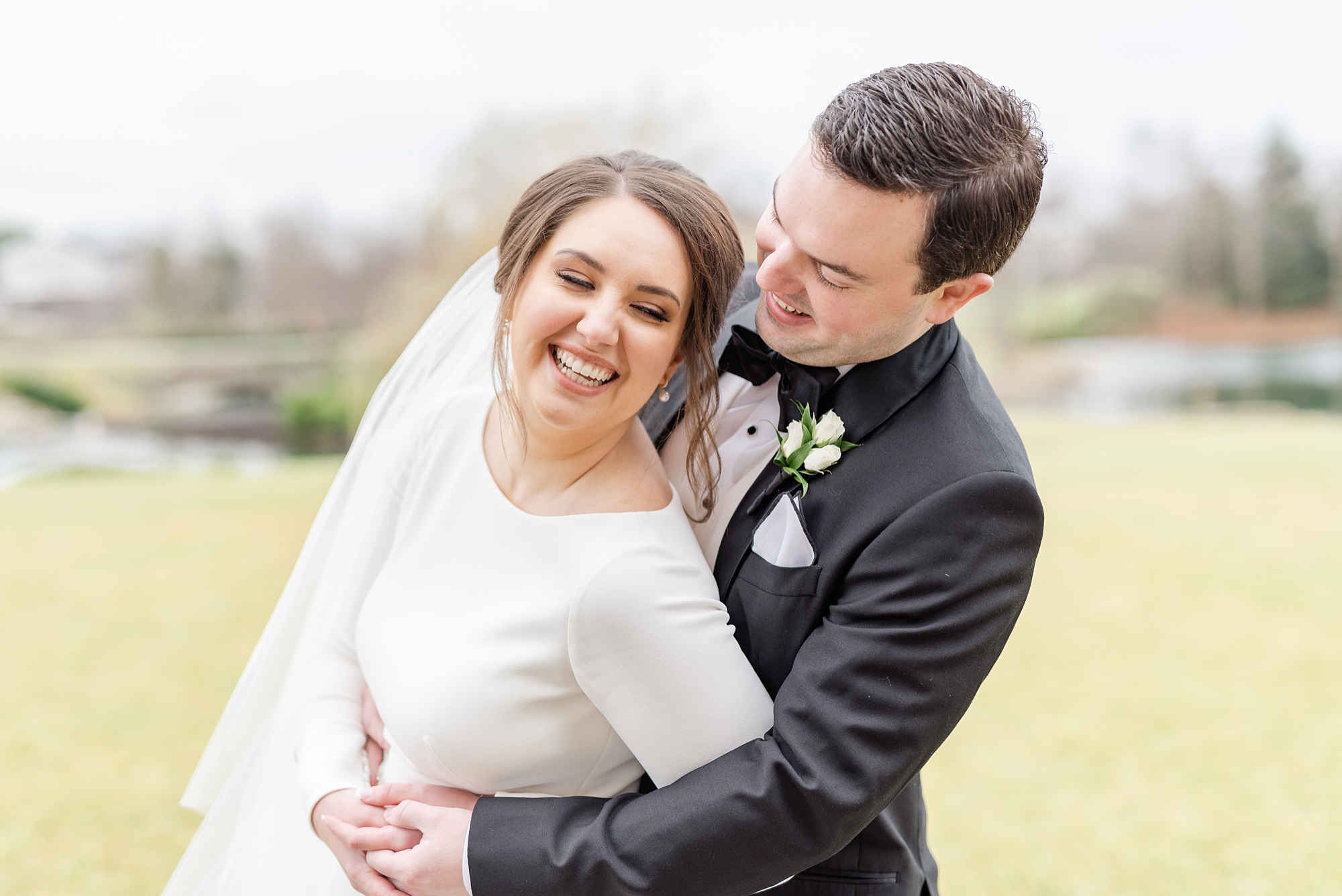 groom hugs bride and rocks her during portraits