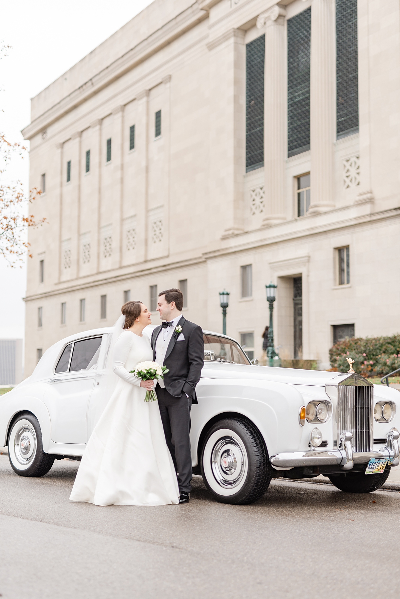 bride and groom pose with classic car at Dayton Masonic Center