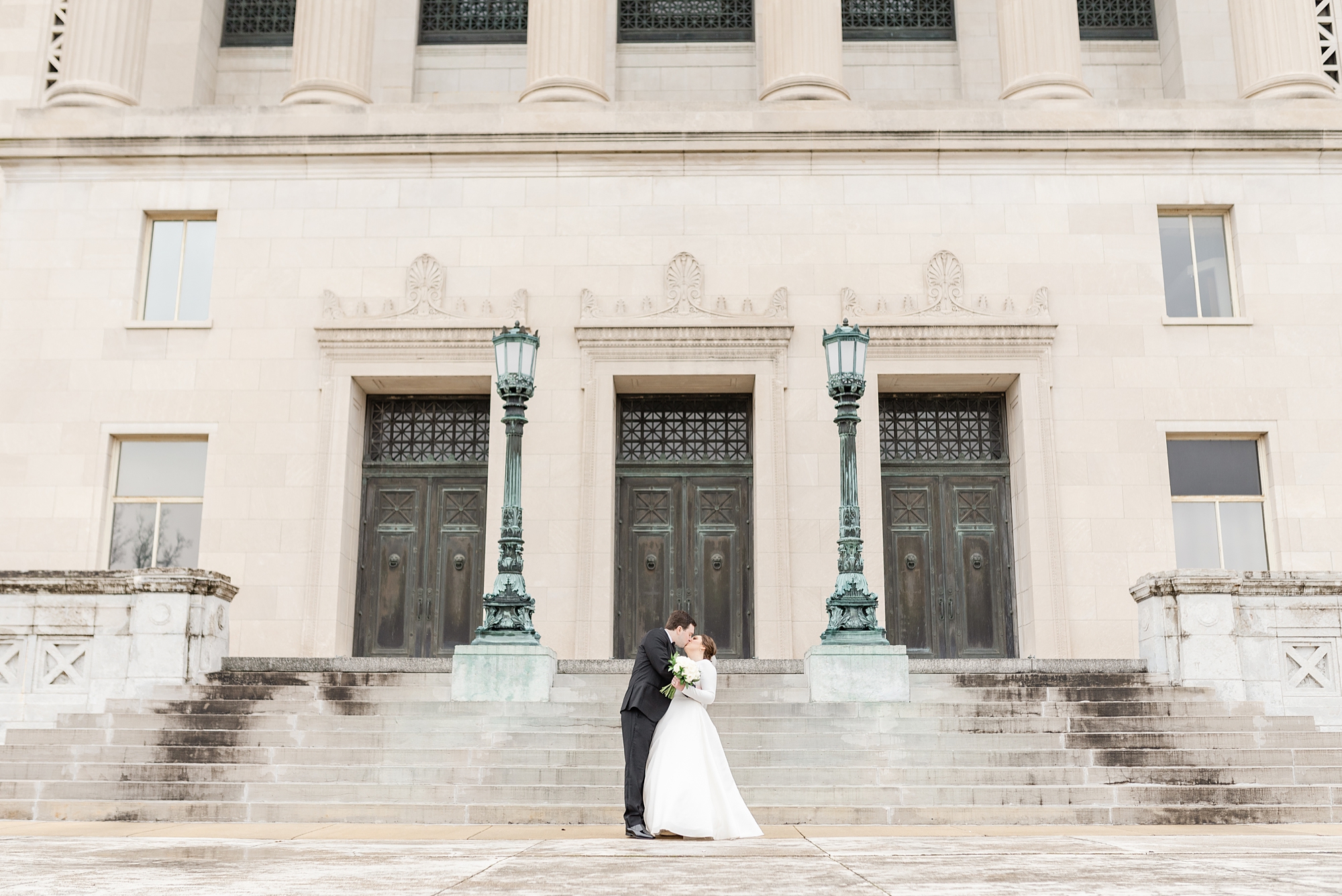 bride and groom kiss outside Dayton Masonic Center