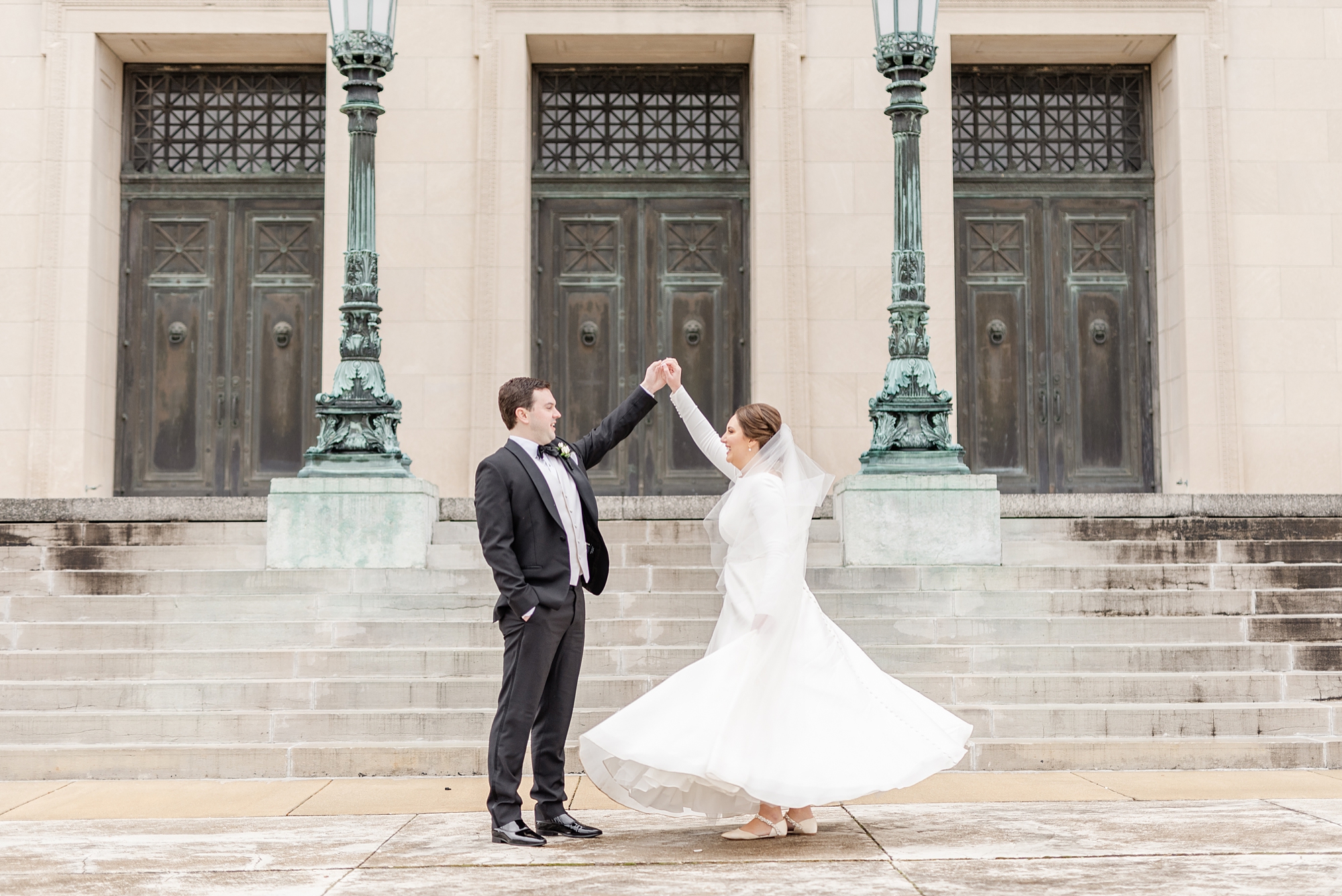 groom twirls bride during portraits by Dayton Masonic Center
