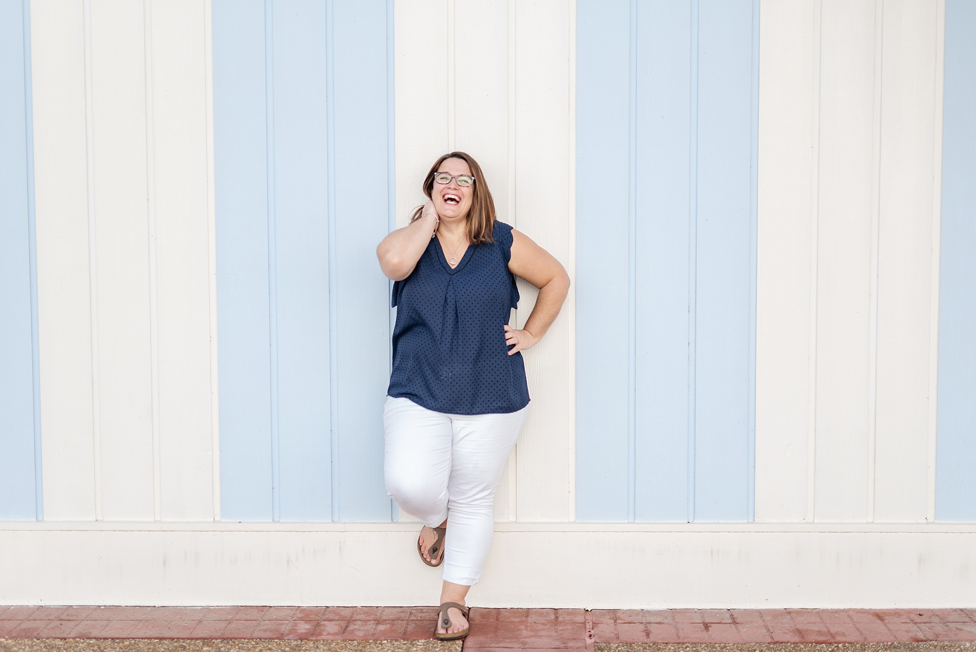 female business owner poses by wall on Disney Boardwalk