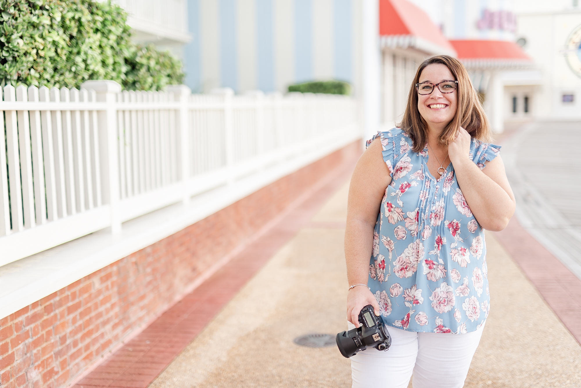 photographer holds camera posing along Disney Boardwalk in Orlando