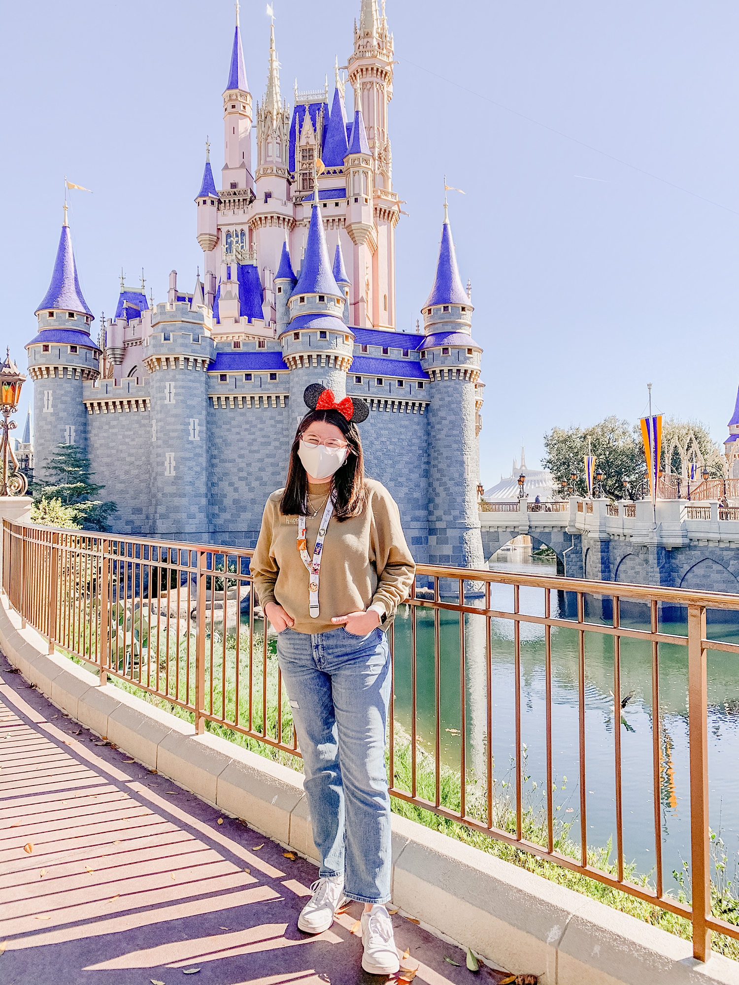 woman in Minnie ears poses by Cinderella Castle in Walt Disney World