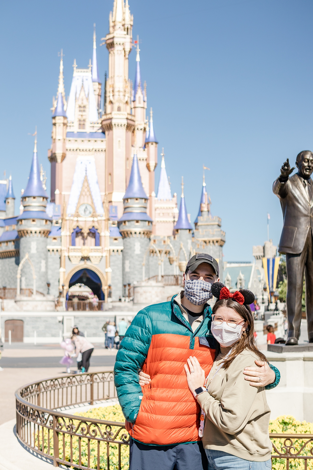 couple poses by castle at Magic Kingdom