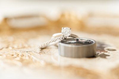 wedding rings rest on wedding invitation