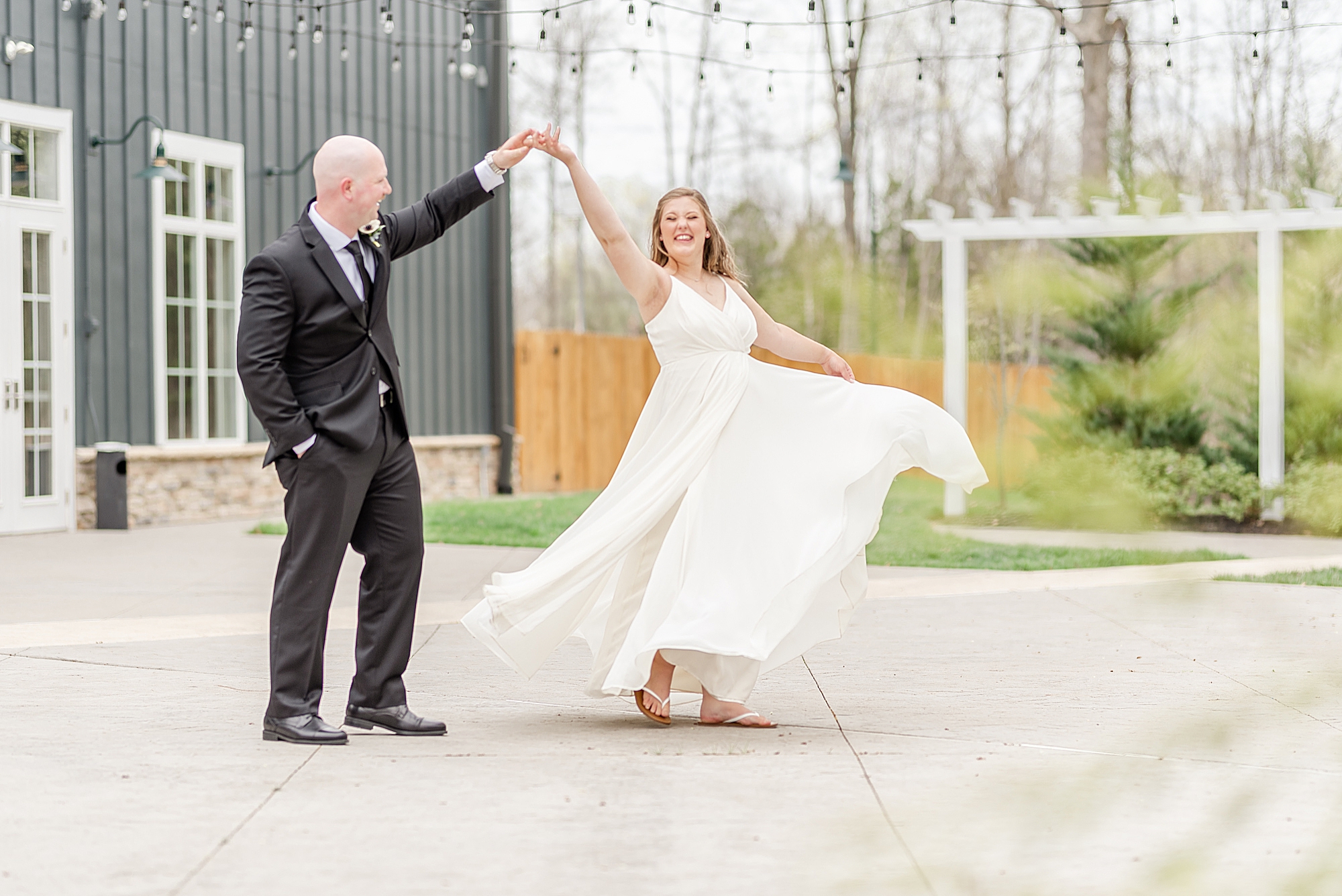 groom twirls bride outside Estate at New Albany