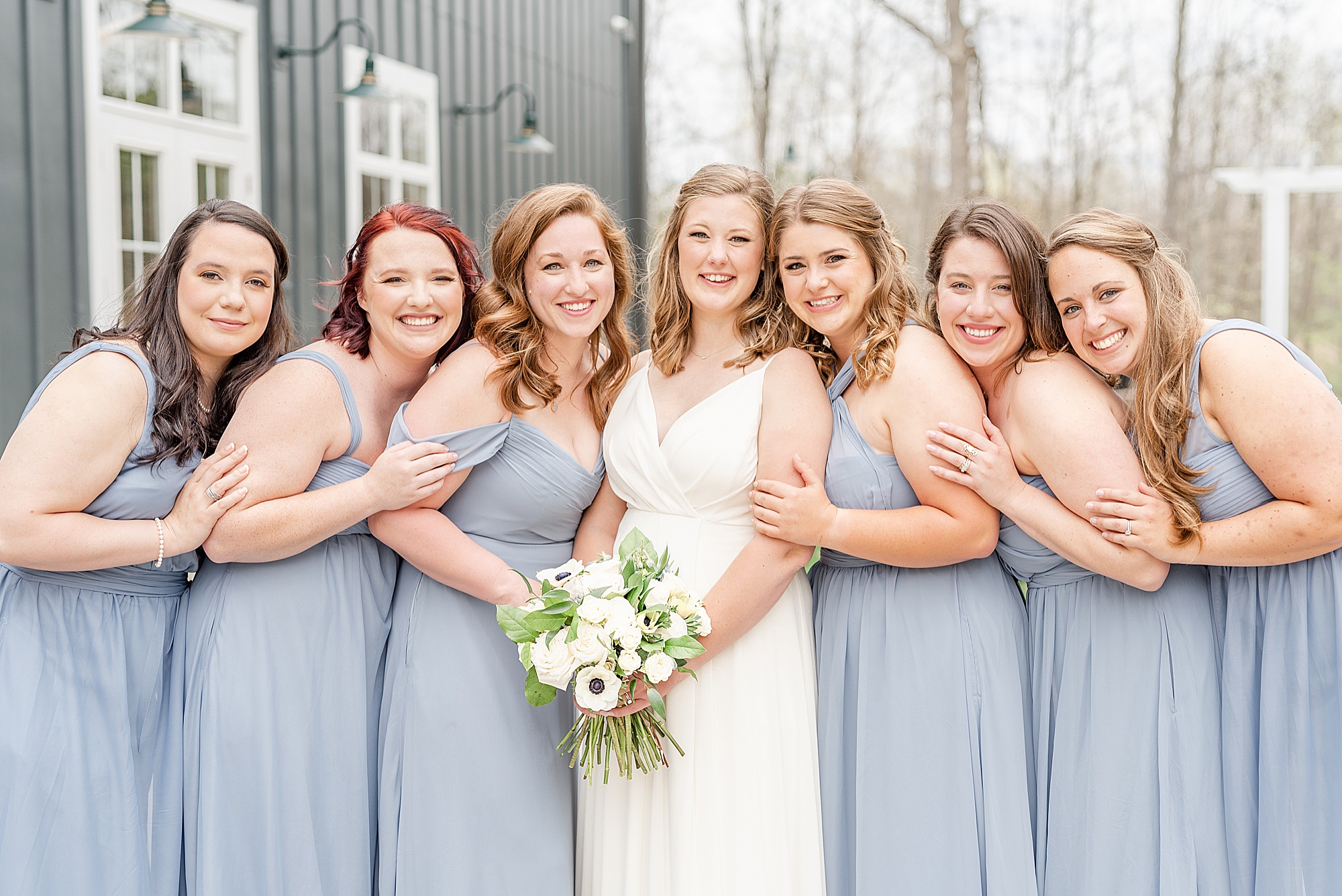 bridesmaids lean on bride during photos at The Estate at New Albany