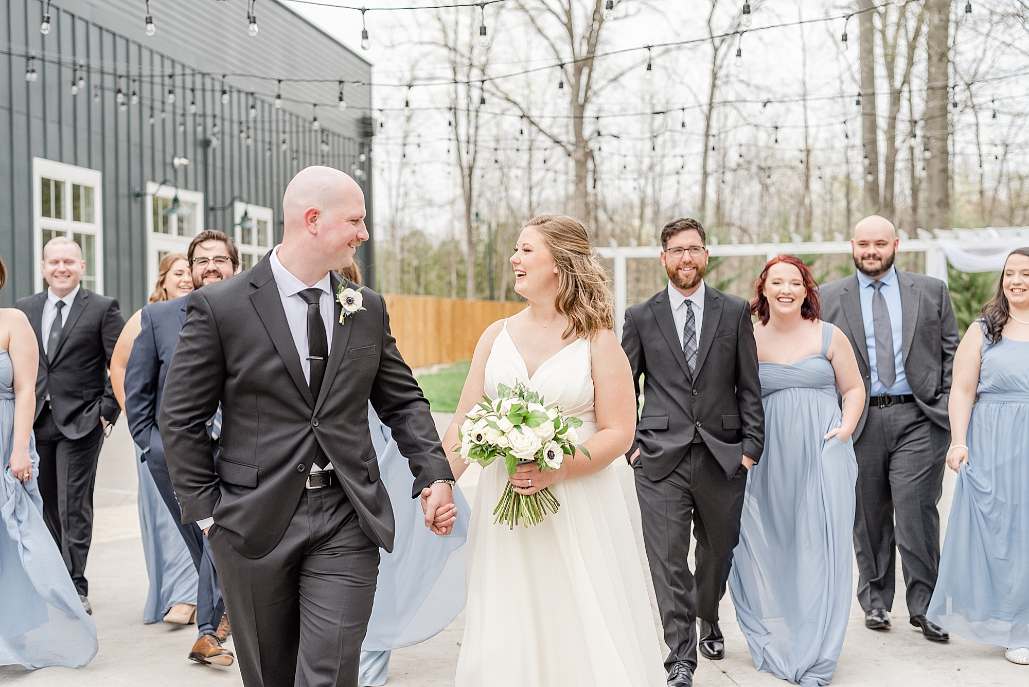 bride and groom walk with bridal party outside The Estate at New Albany