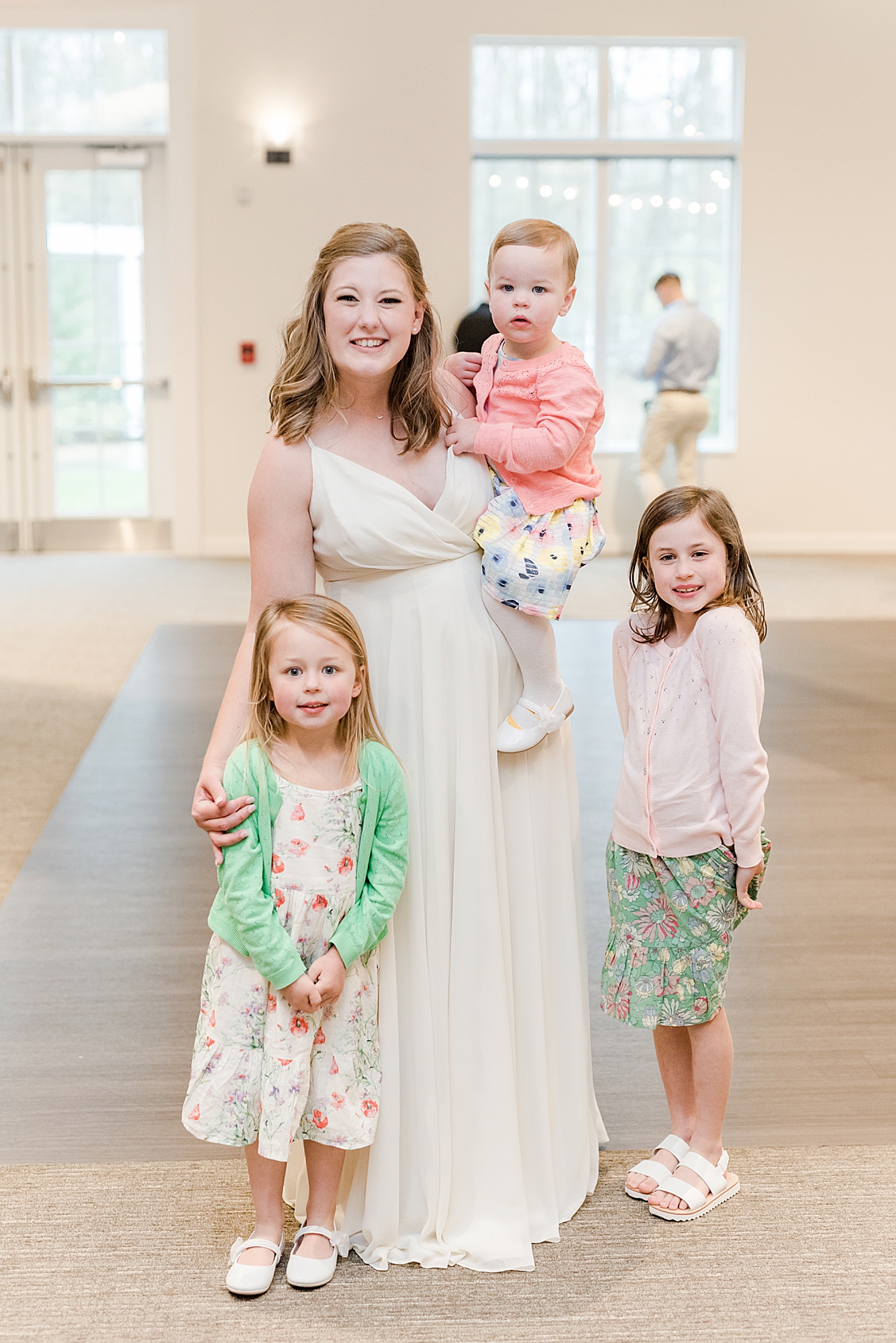 bride poses with children during OH wedding reception