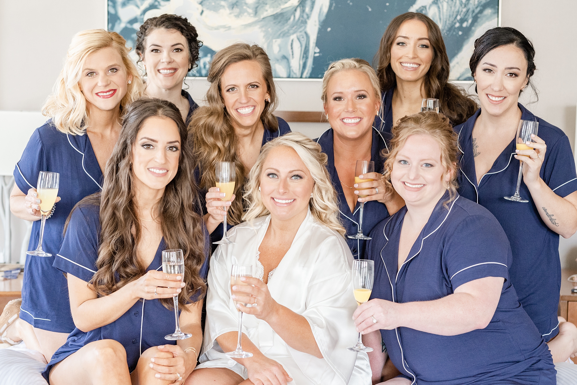 bride poses with bridesmaids in matching blue pajamas