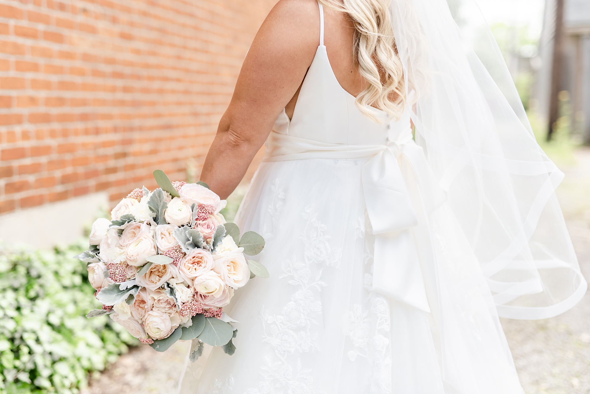 bride shows off pastel pink wedding bouquet