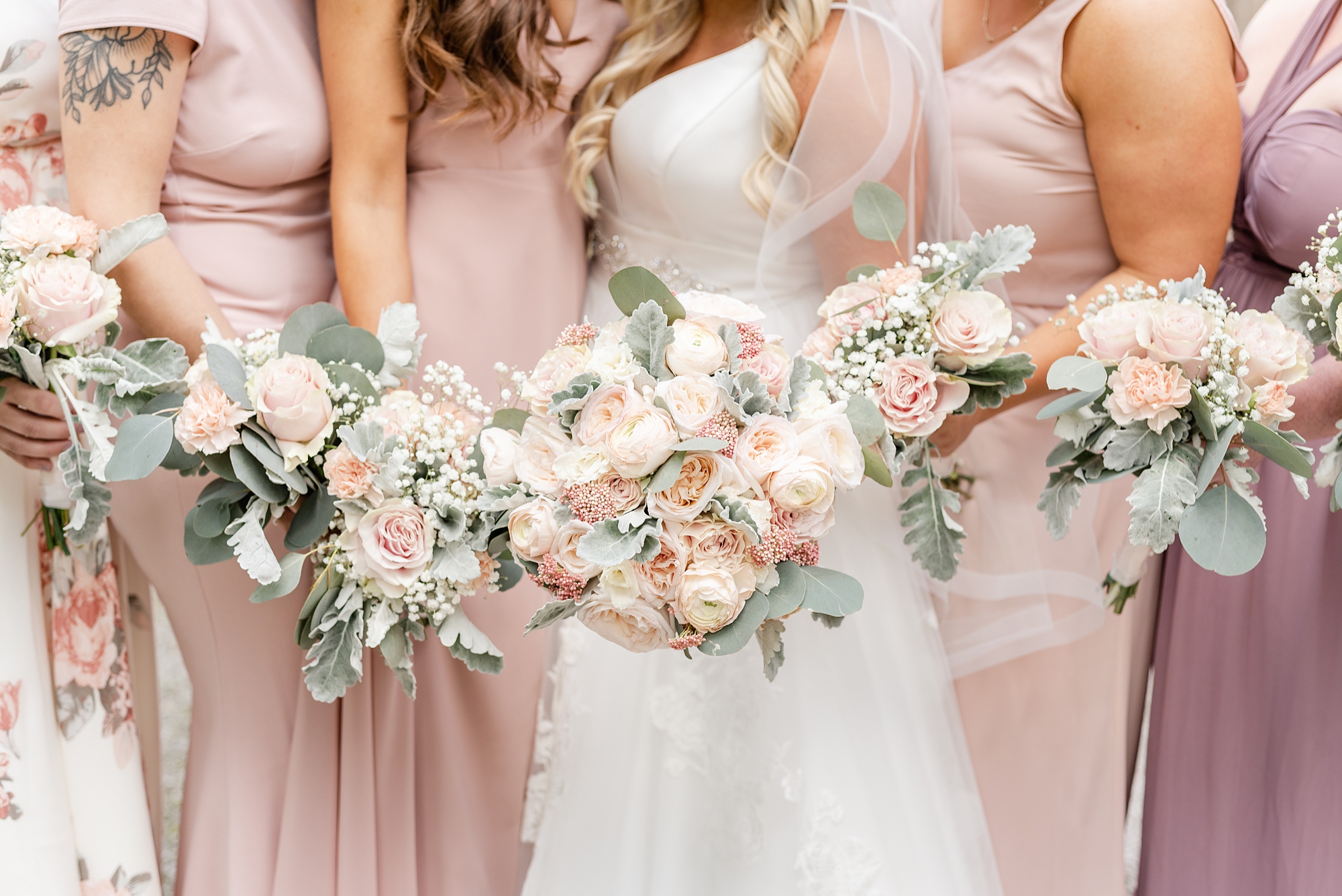 bride and bridesmaids hold pink bouquets outside High Line Car House