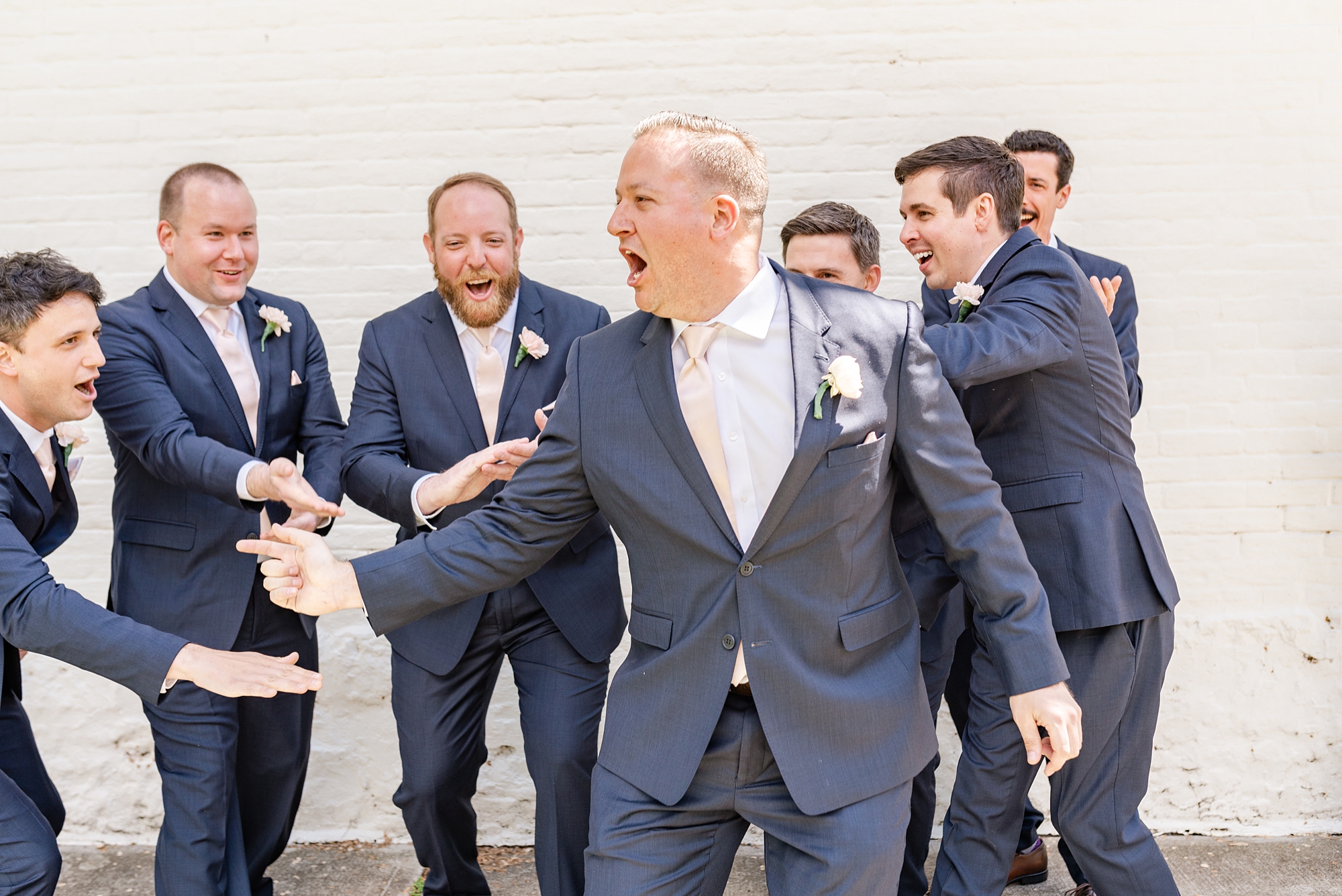 groom laughs with groomsmen in Ohio