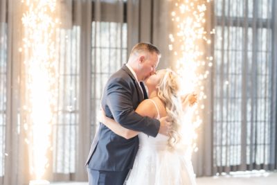 groom kisses bride during first dance by pyrotechnic display