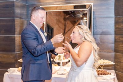 groom feeds bride wedding cake in Ohio