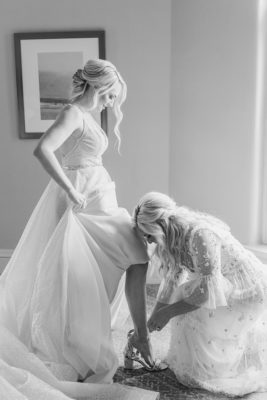 mother of bride helps bride with shoes