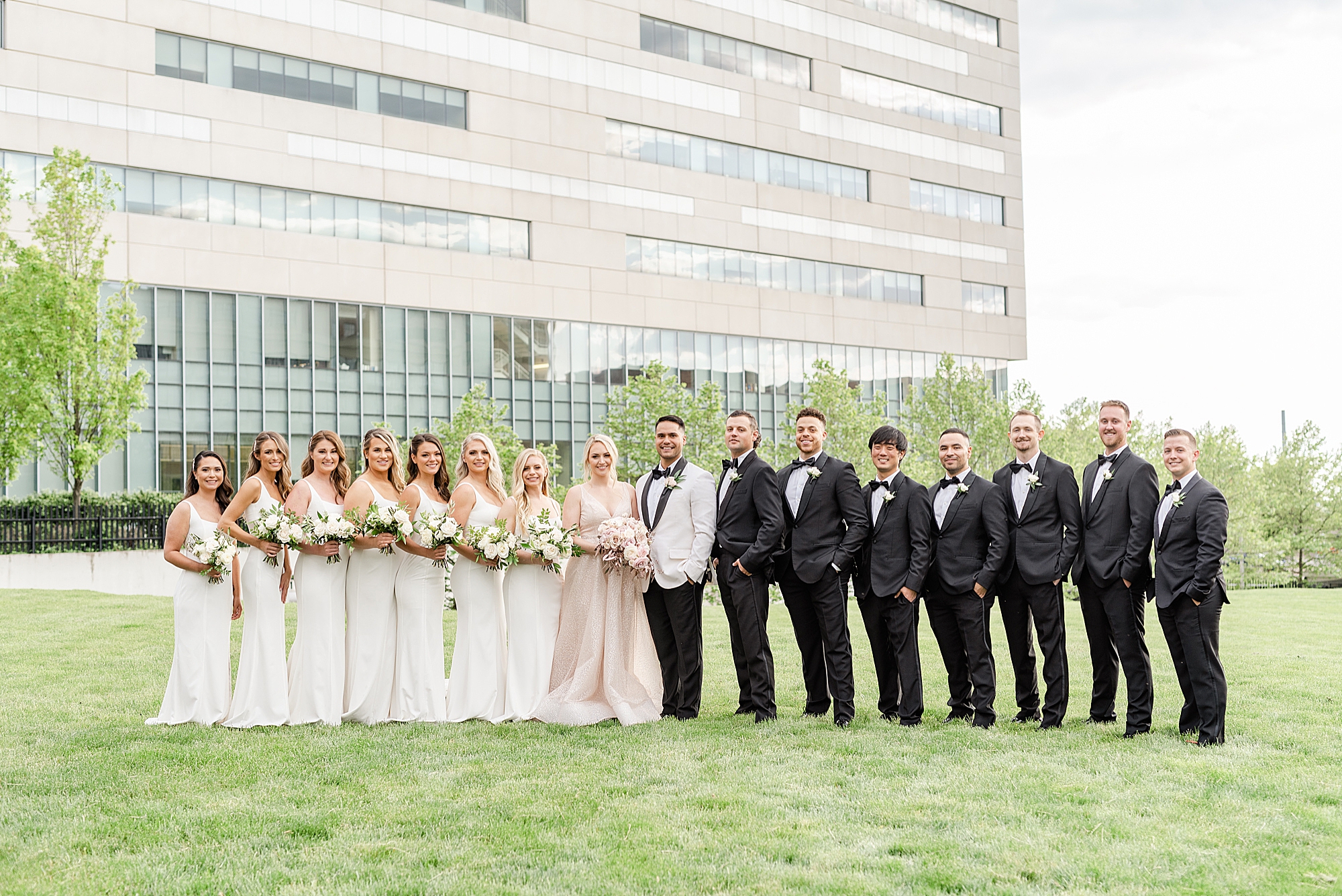 bridal party poses with bride and groom outside Westin Southern Columbus