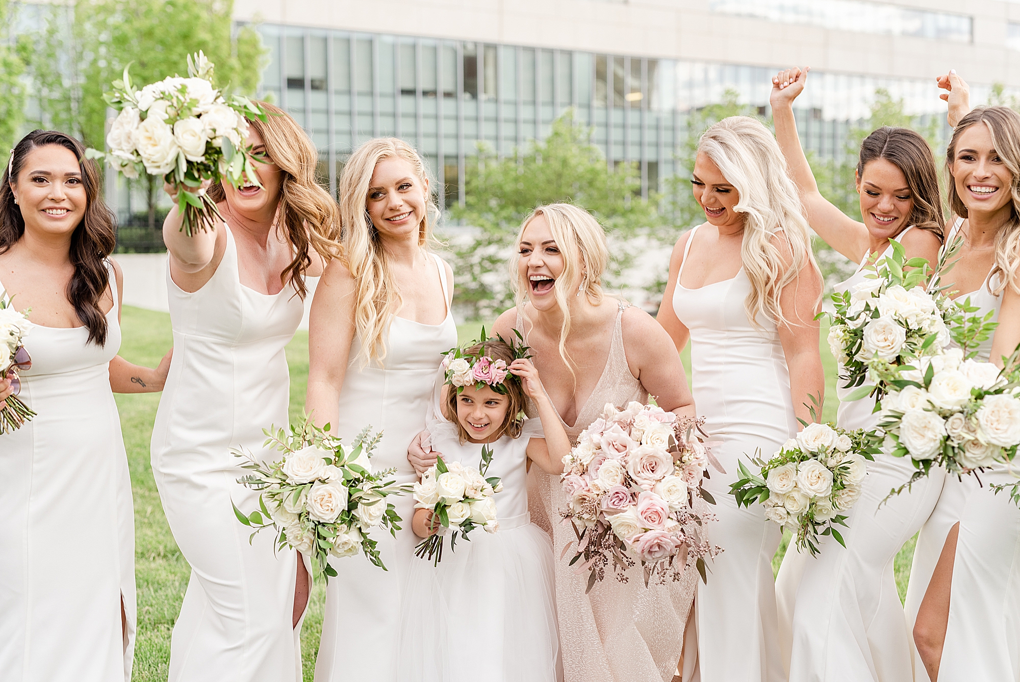 bride laughs with bridesmaids in white gowns
