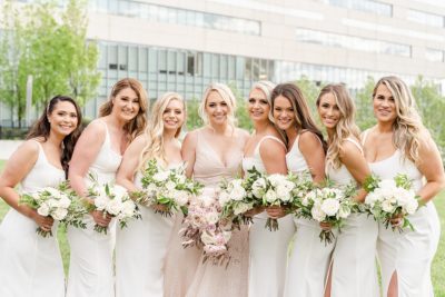 bridesmaids in white gowns pose with bride outside Westin Southern Columbus