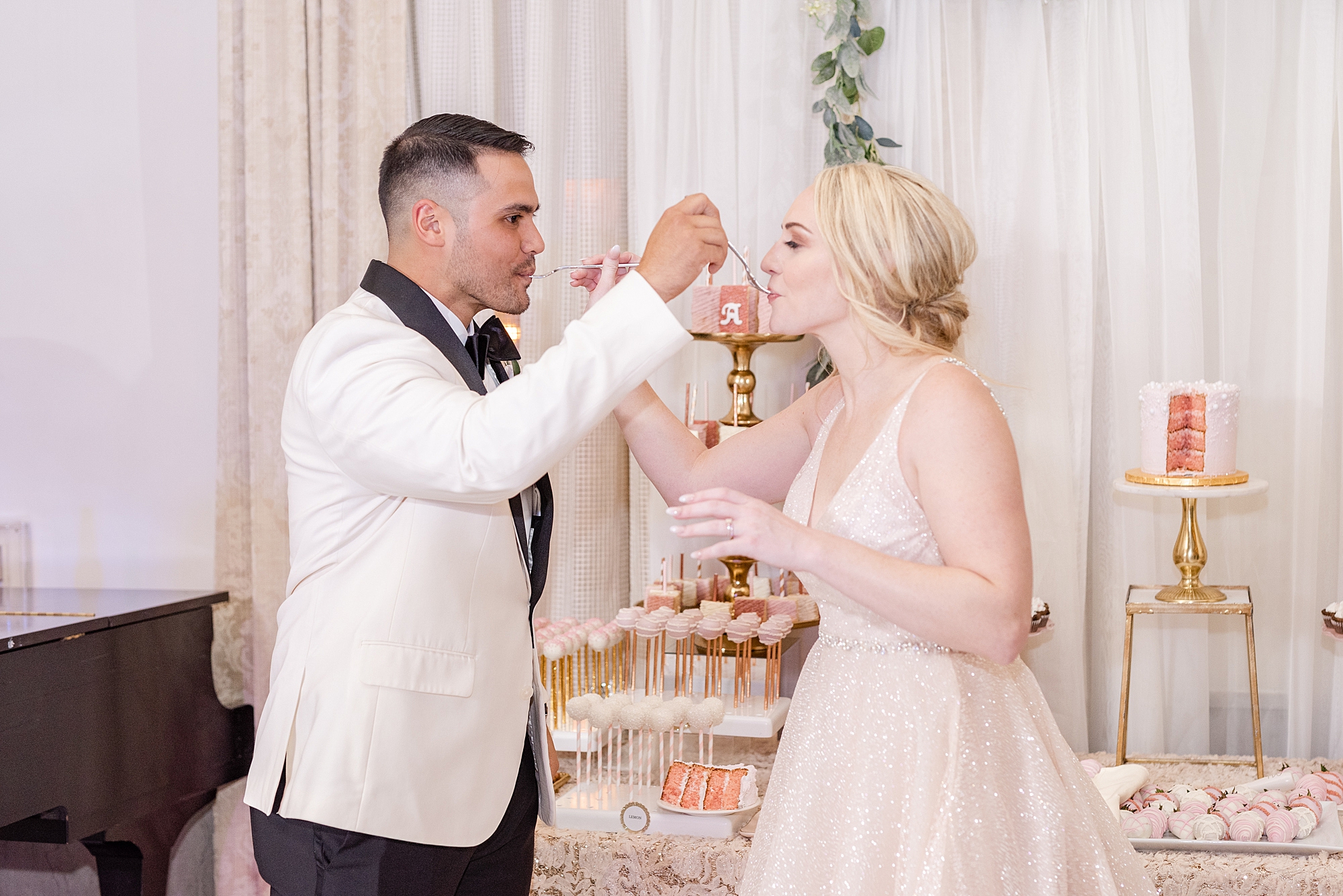 bride and groom taste wedding desserts