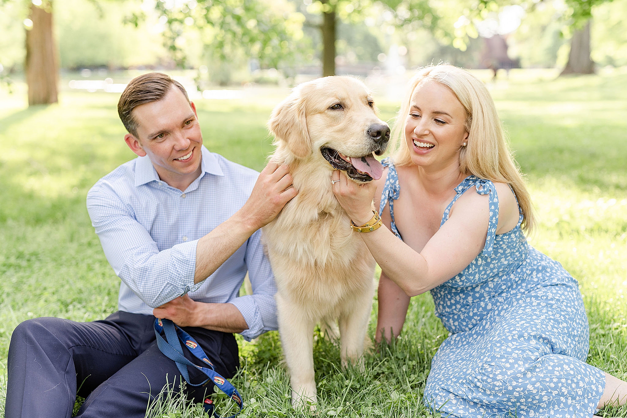 engaged couple sits with golden retriever during downtown Columbus engagement session