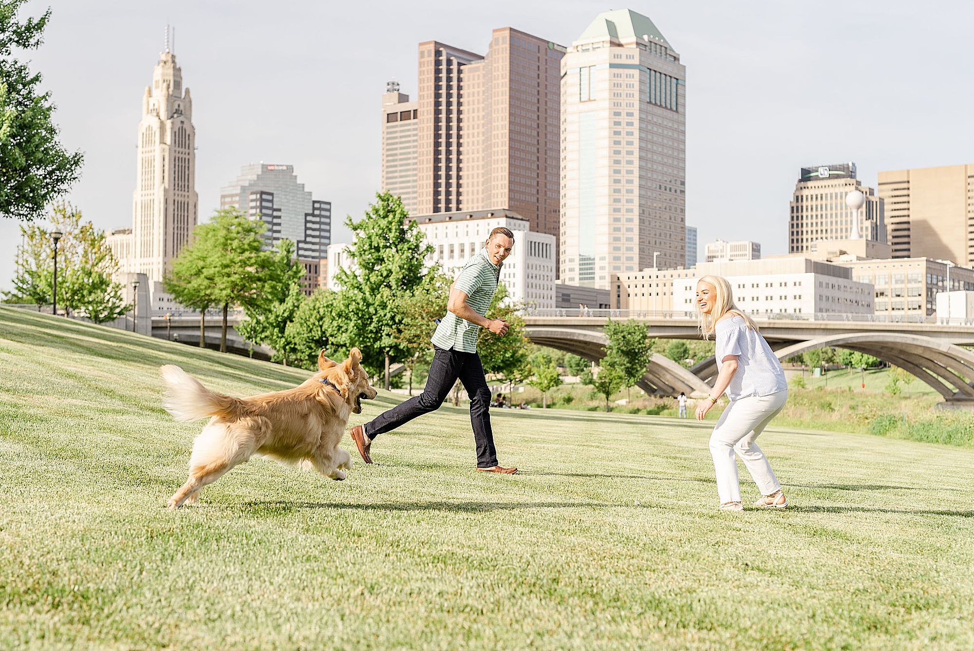 couple plays with dog during downtown Columbus engagement photos