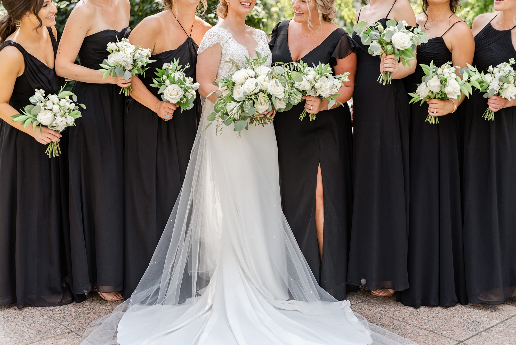 bride and bridesmaids hold bouquets of white flowers