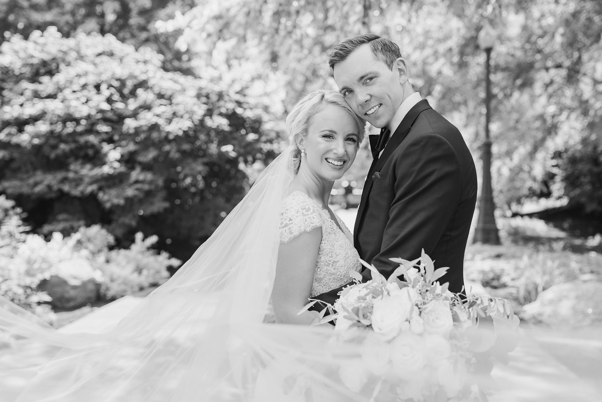 newlyweds hug with bride's veil floating in Ohio