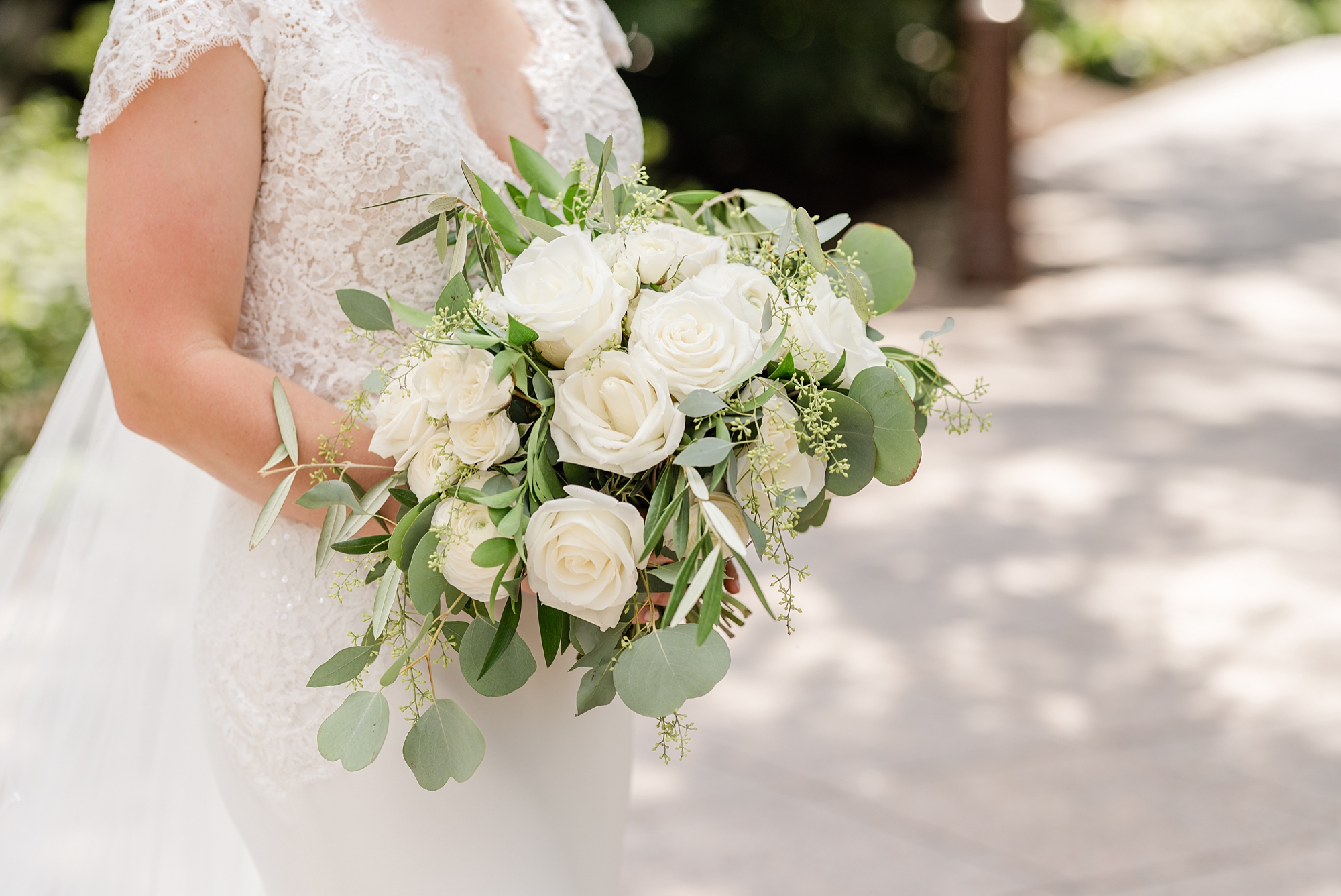 bride holds bouquet of ivory flowers