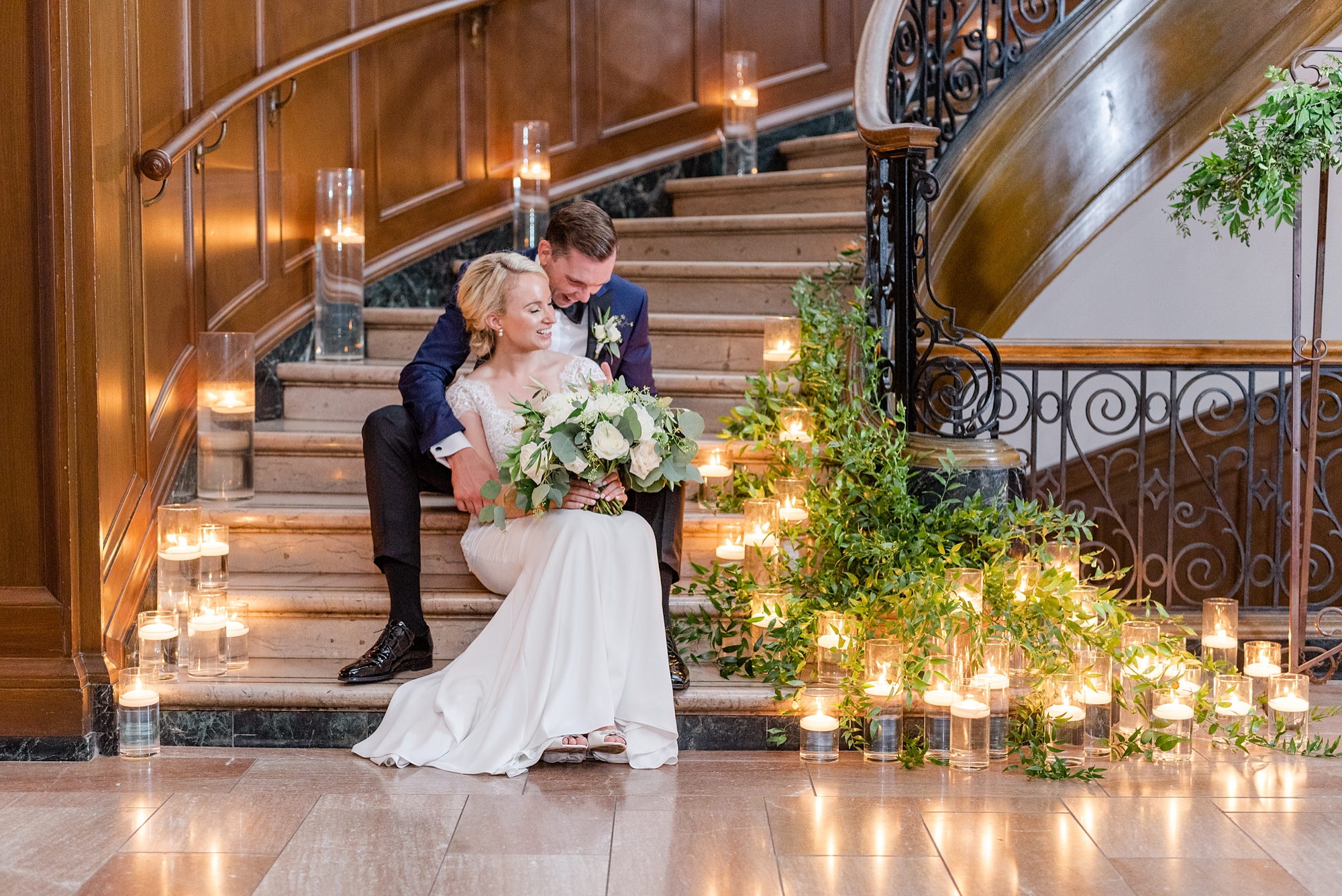 bride and groom hug on steps with lights around them