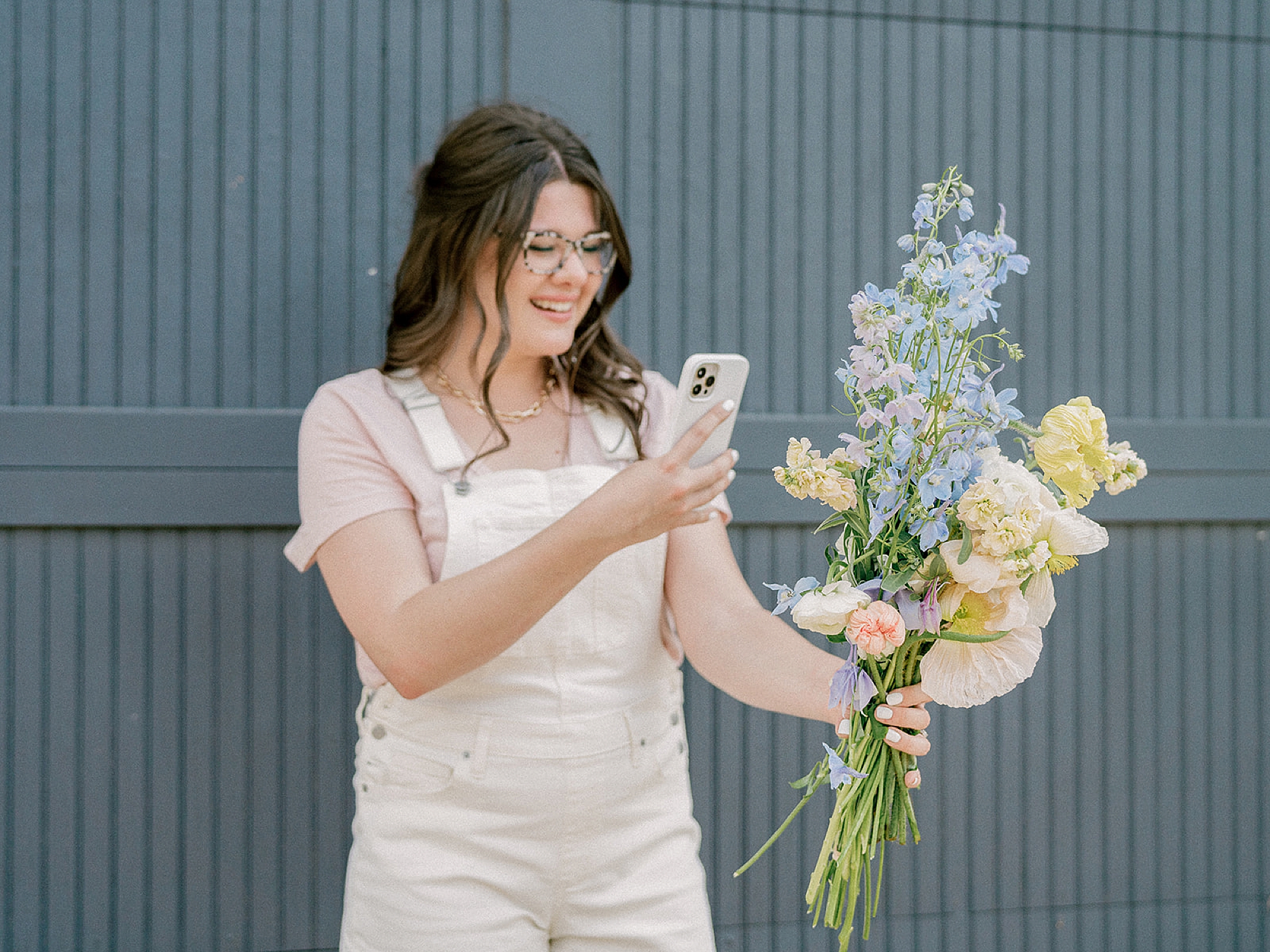 business educator holds bouquet in front of her and takes photo
