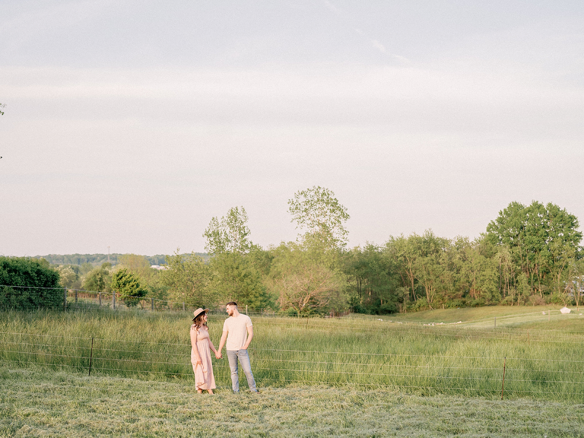 young couple poses in field during Ohio anniversary photos