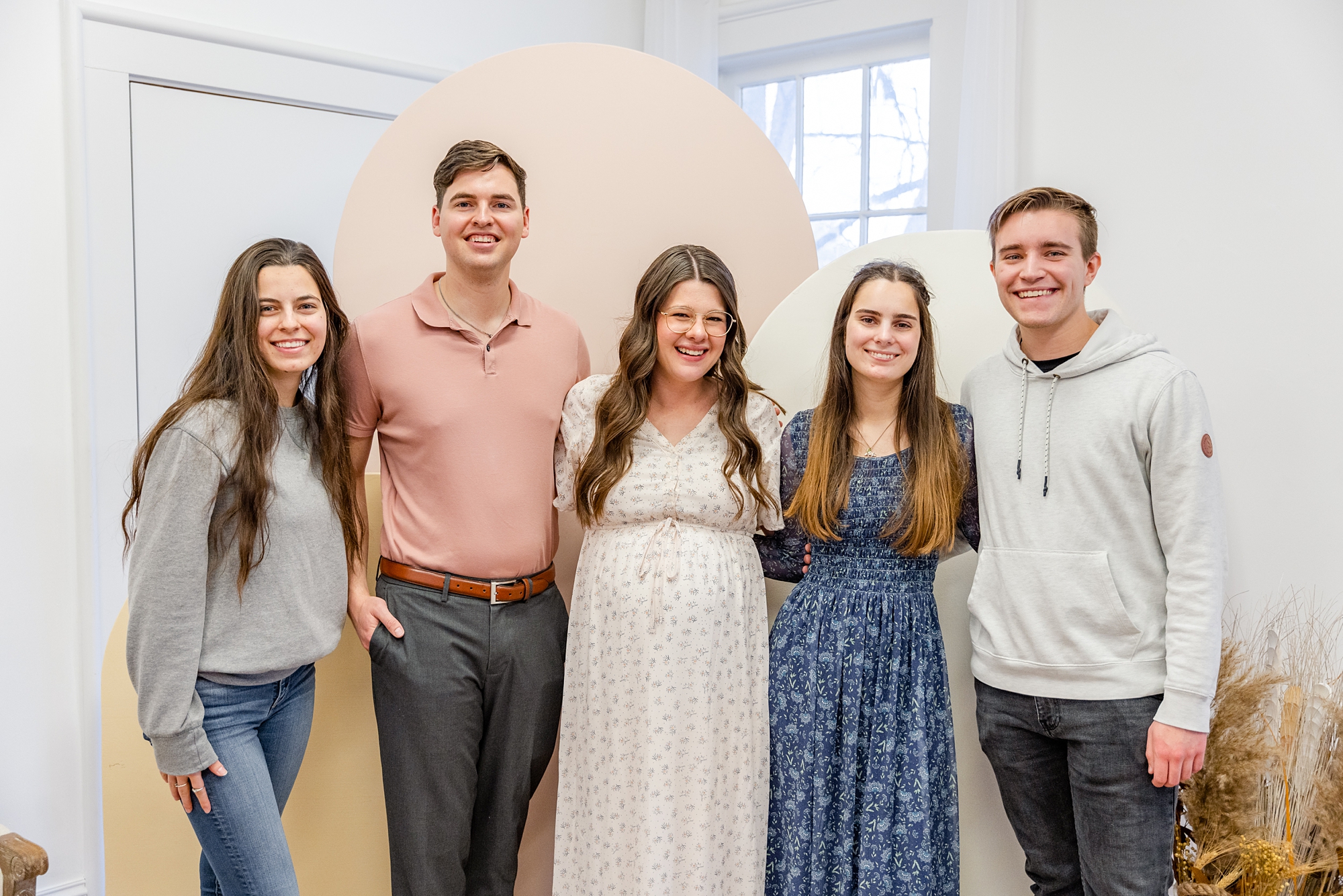 guests hold mom's belly during baby shower