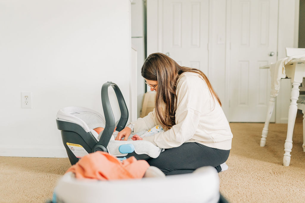 woman gets daughter out of carseat during lifestyle newborn session