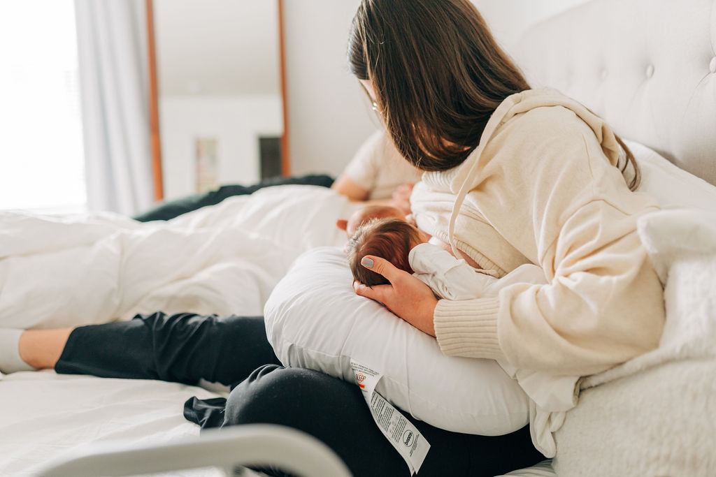 mom latches babies during lifestyle newborn photos