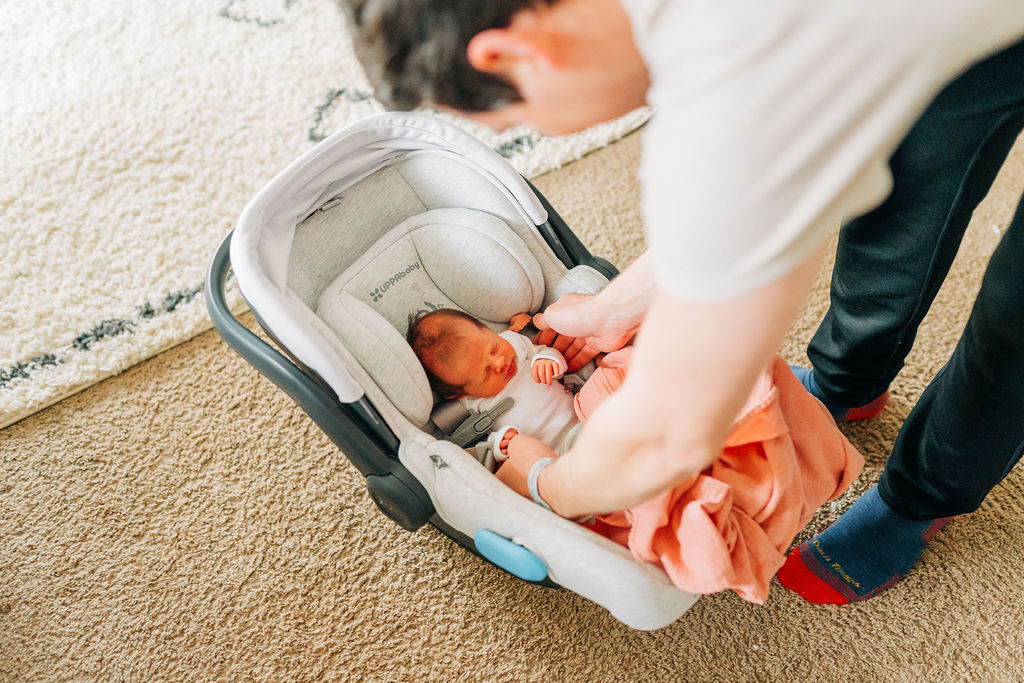dad gets baby out of carseat during lifestyle portraits