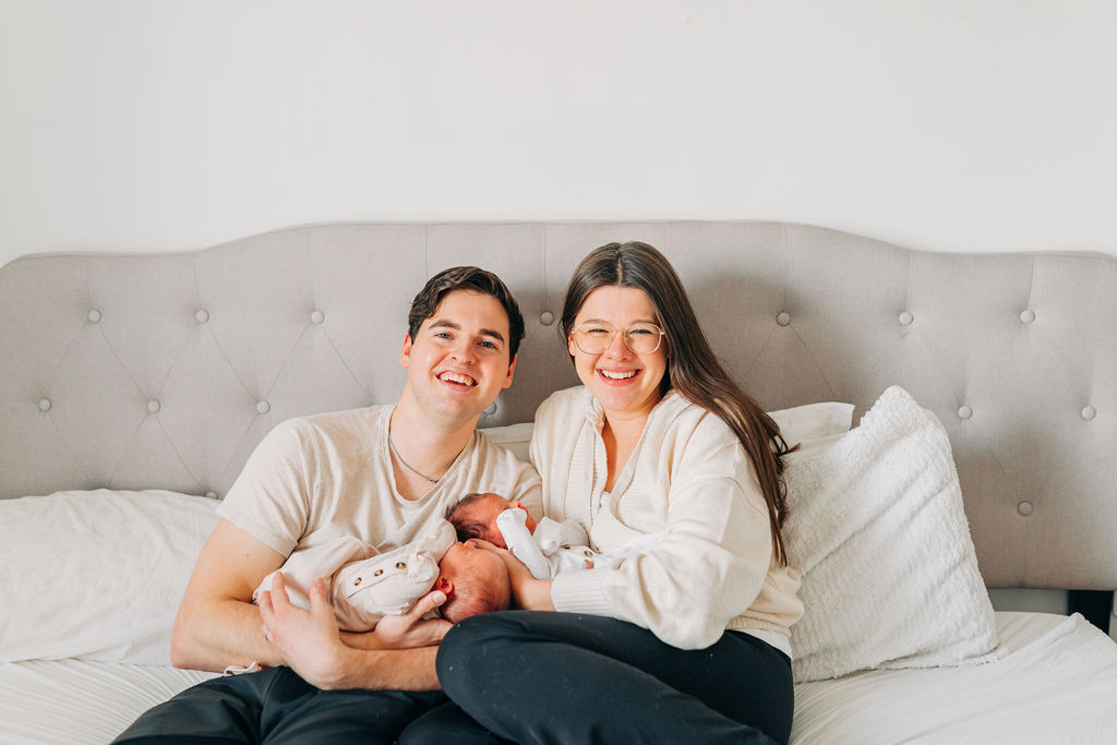 new parents smile holding twin girls