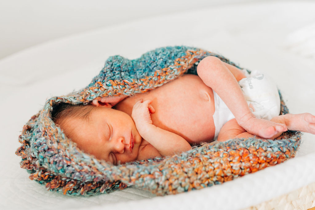 baby lays on changing table in knit scale bag