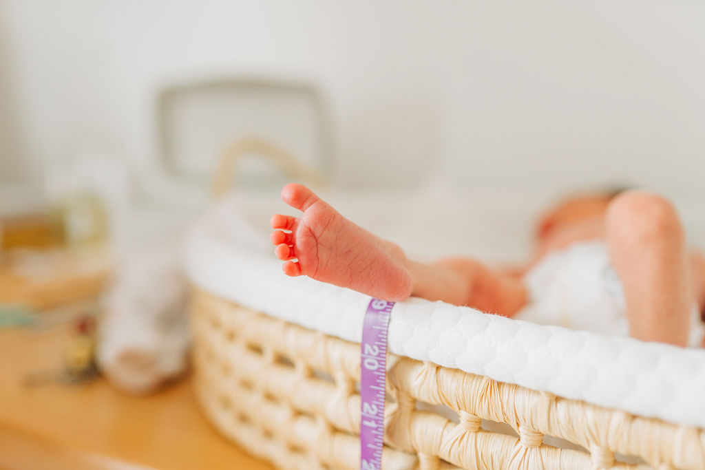 baby's foot hangs over basket