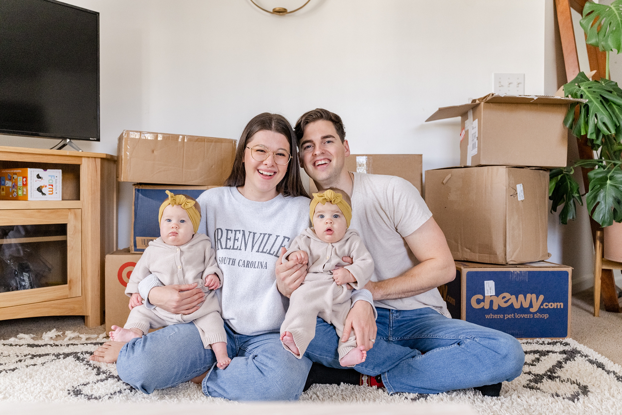 parents sit with babies by moving boxes